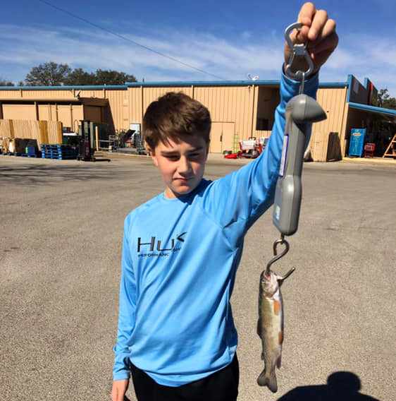 Young angler holding a stringer of rainbow trout